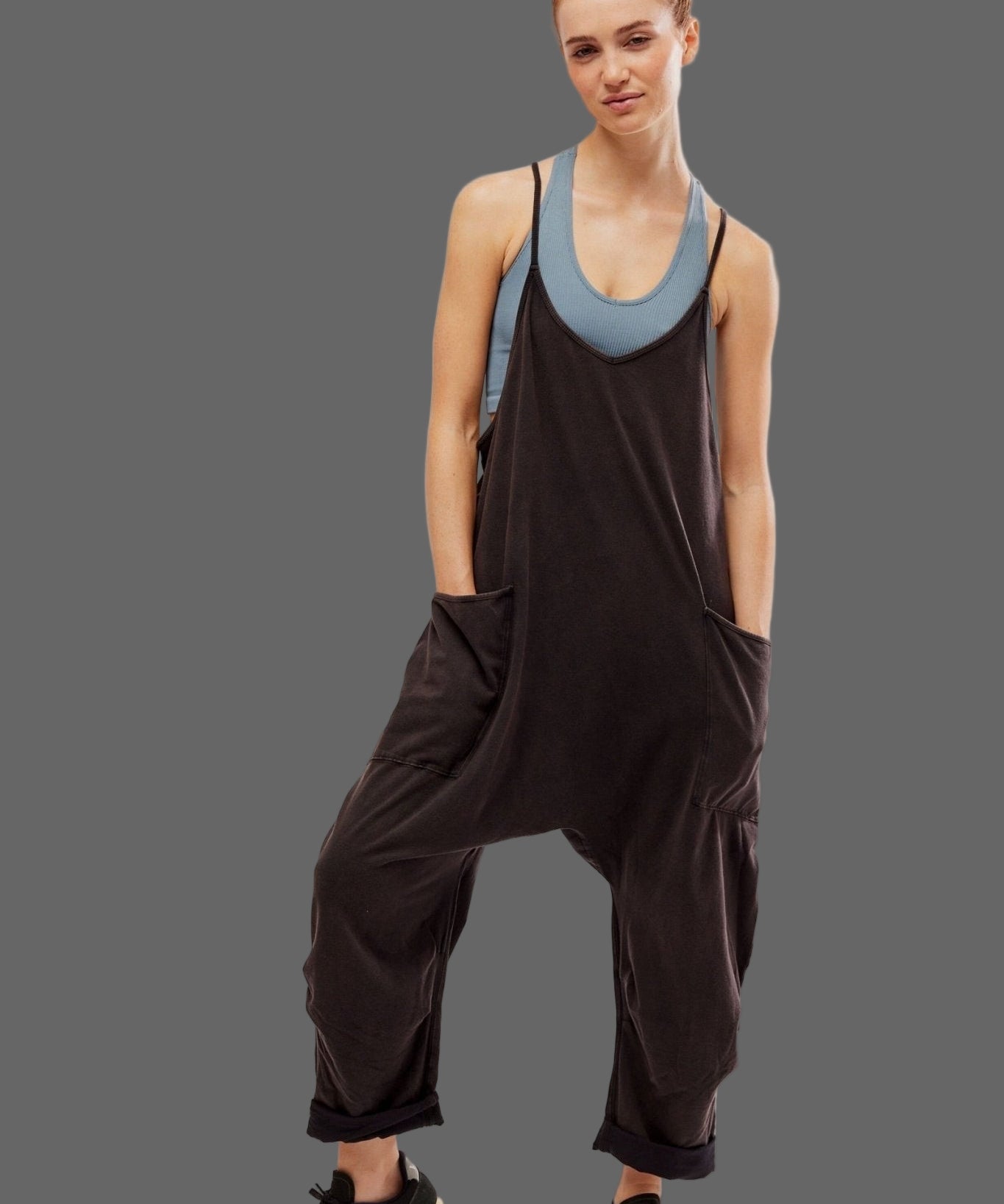 Person wearing a black sleeveless jumpsuit with a blue inner lining on a white background